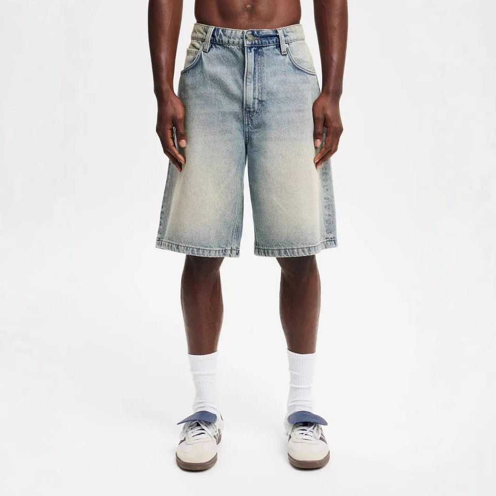 Men's loose fit light blue cotton denim straight leg trousers on a neutral background