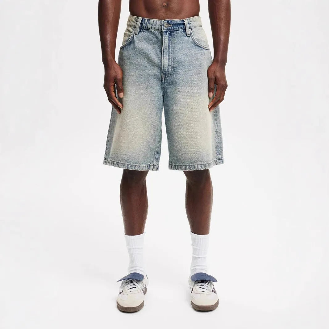 Men's loose fit light blue cotton denim straight leg trousers on a neutral background