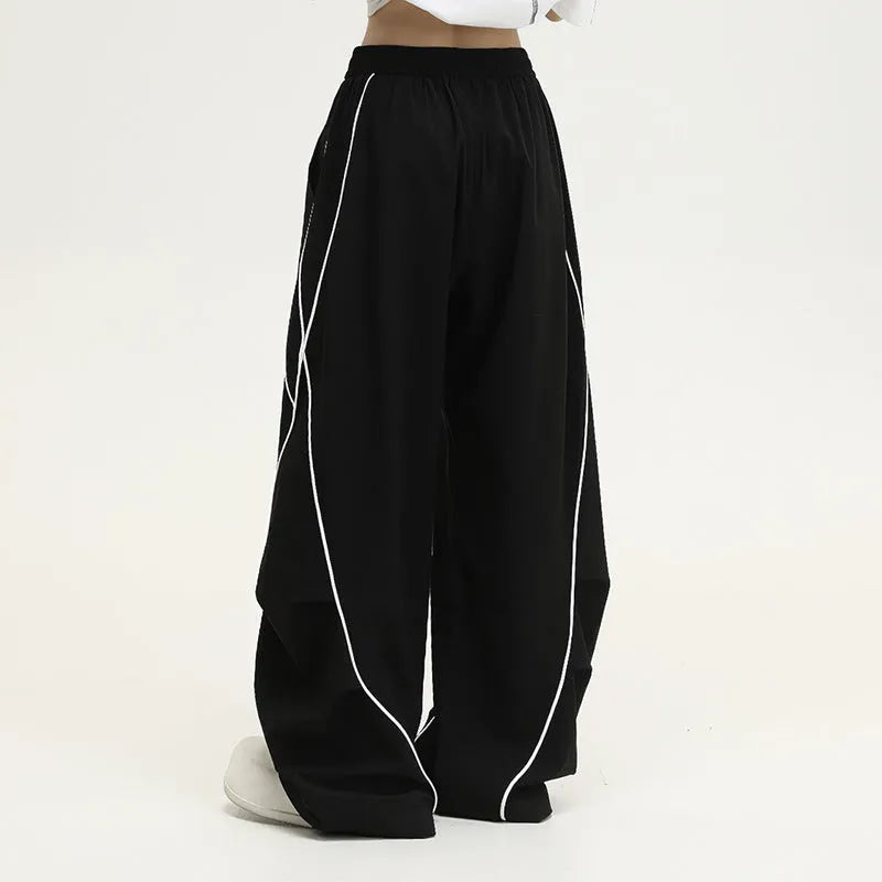 Black striped pleated hip hop sports wide-leg pants on hanger showing loose fit and mid-waist design
