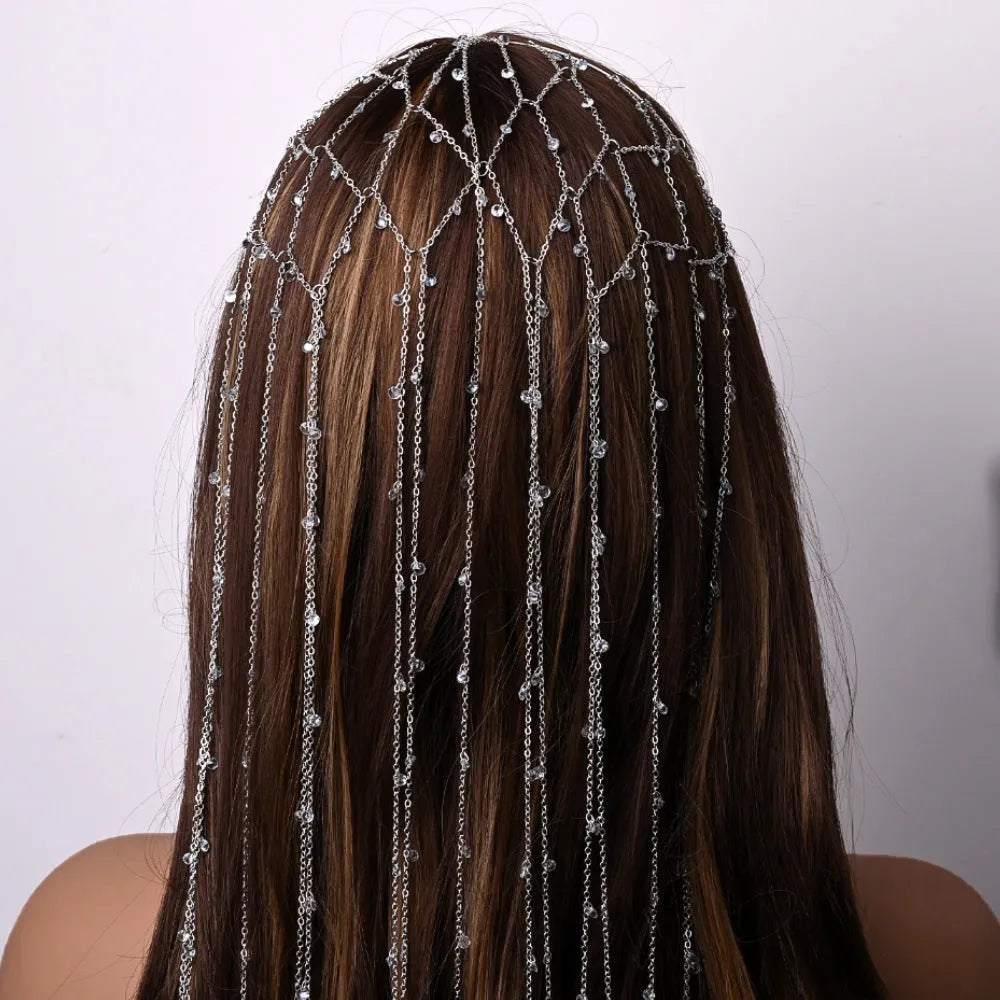 Gold coloured rhinestone hair band with a draped mesh tassel decoration.