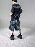 Blue denim shorts with frayed hems and star patches in loose fit American retro style