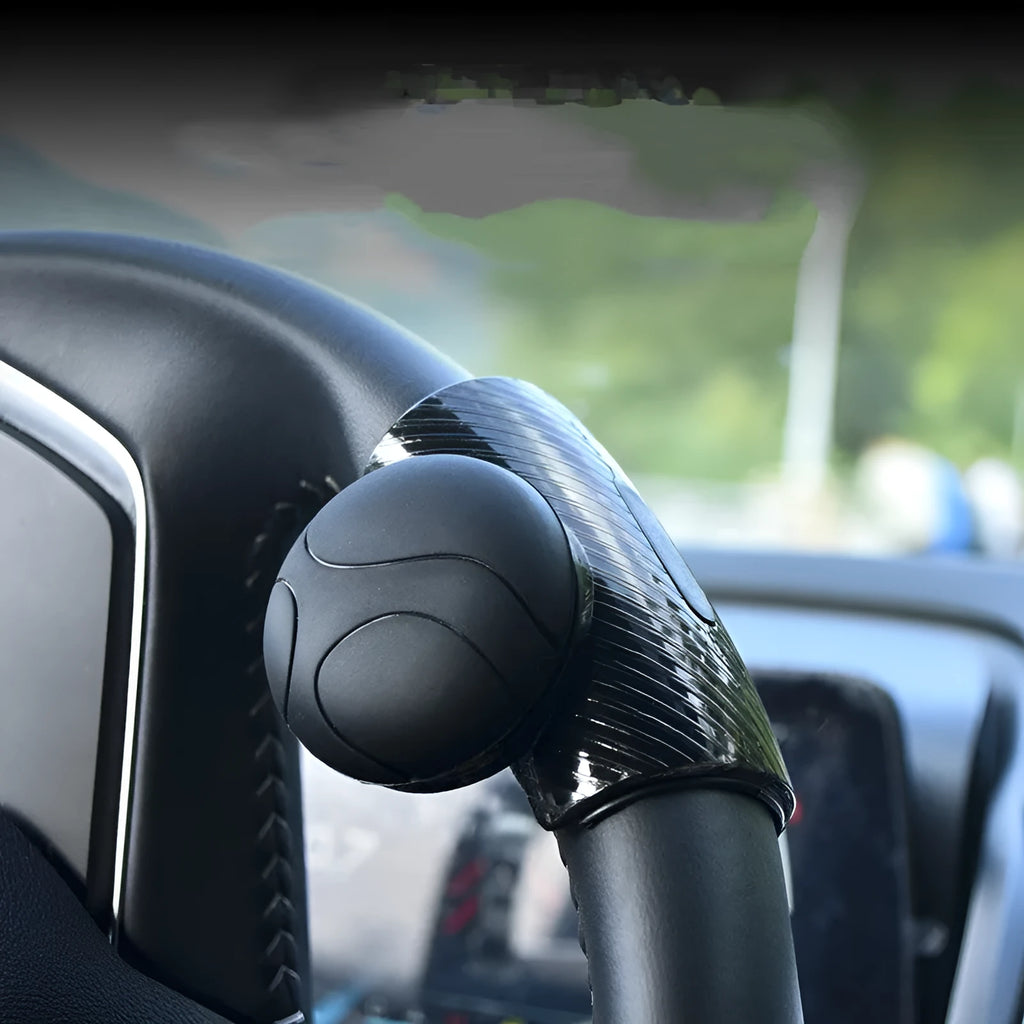 Black silicone steering wheel assist ball with metal bearing, shown next to a blue version.