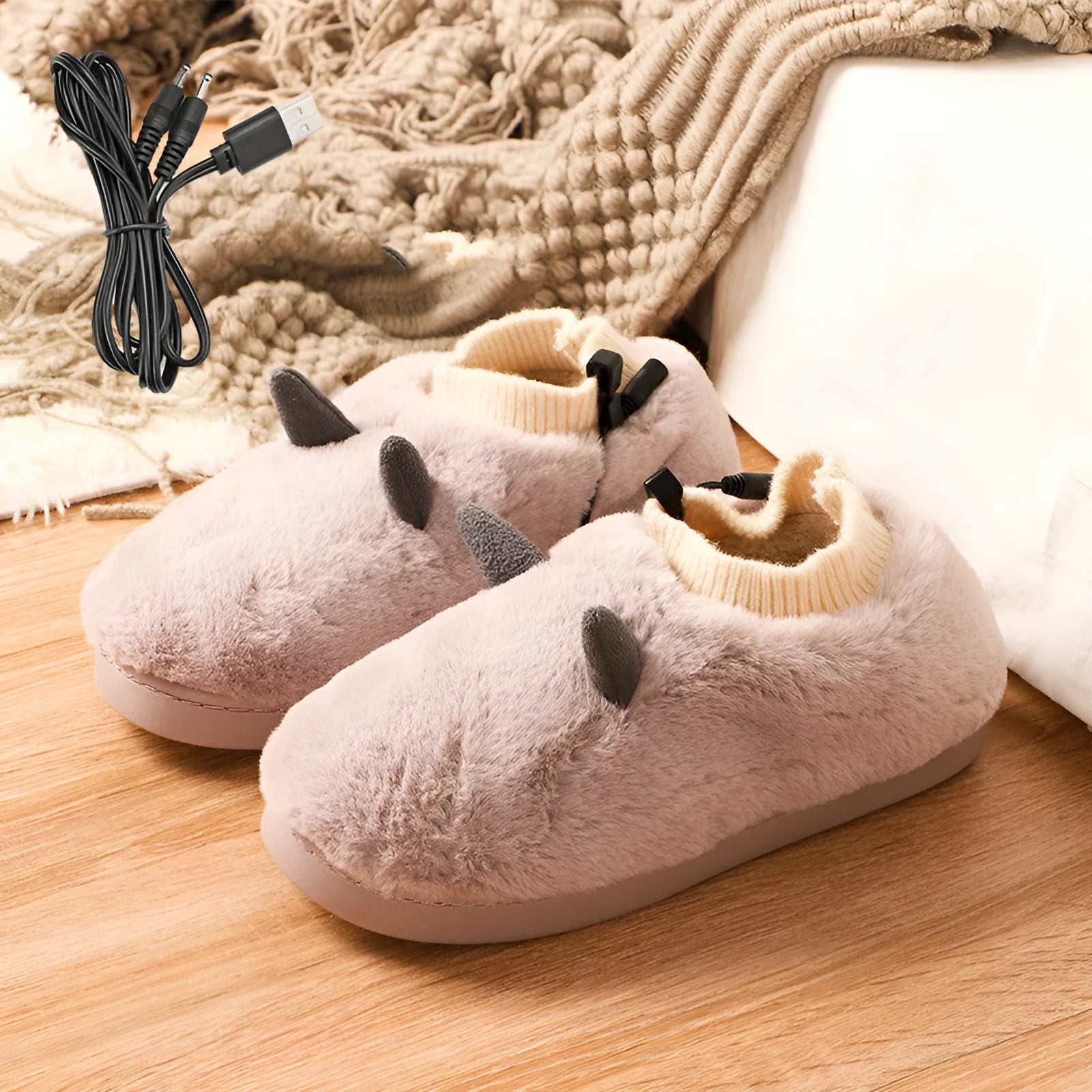 USB electric foot warmer slippers in grey with a connected USB cable on a wooden floor.