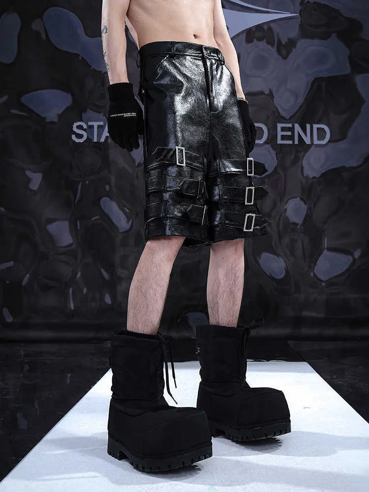 Black men's PU leather cropped shorts with a ring detail on the leg, shown on a model.