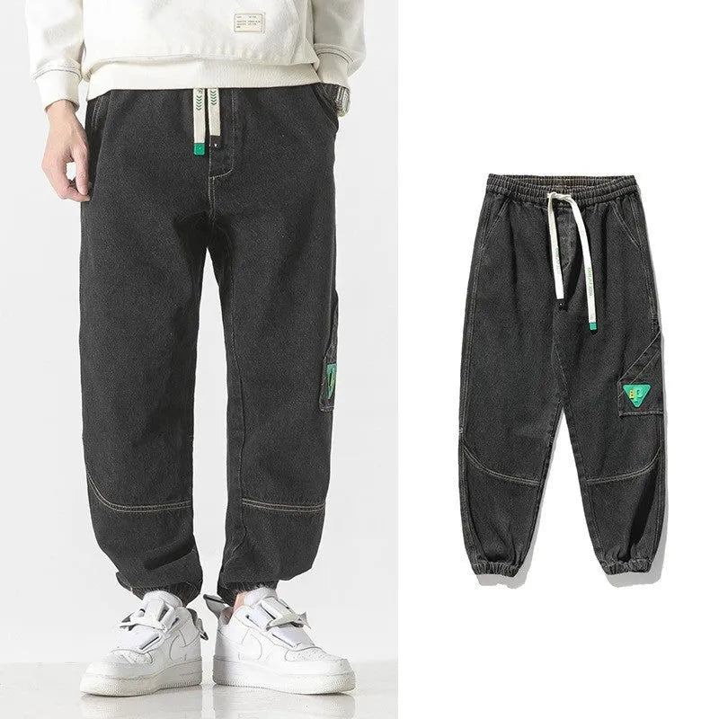 Men's loose-fit tapered cotton trousers showing tapered leg and mid-waist design in black colour