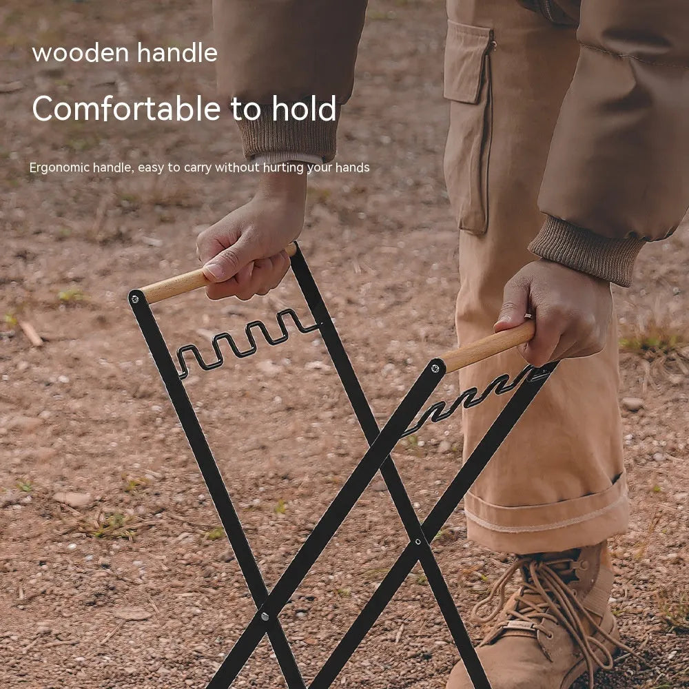 Black folding outdoor trash rack with wooden handle standing on a patio.