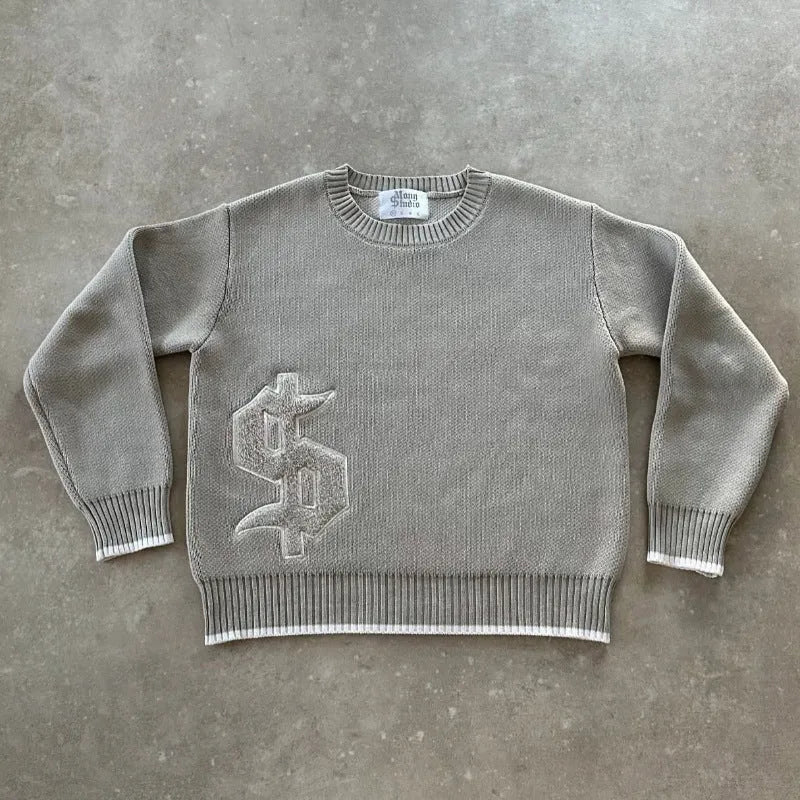 Grey loose-fitting jacquard knit coat on a hanger, showing long sleeves and textured knit pattern.