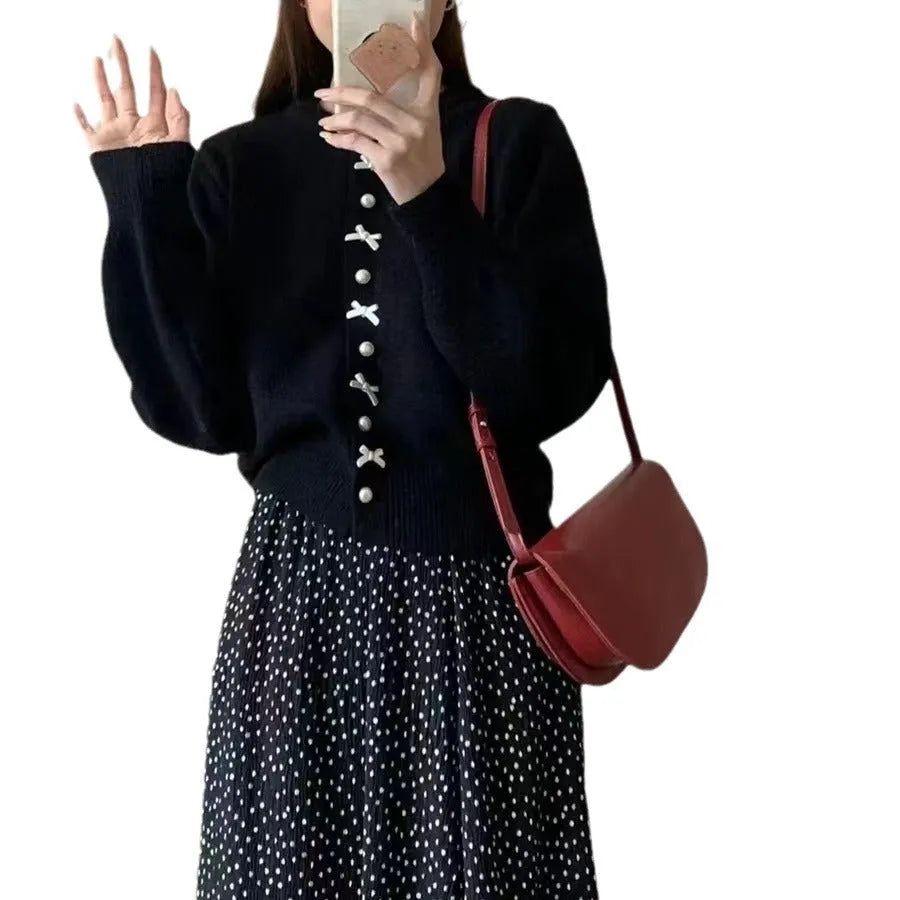 Women's light blue acrylic cardigan sweater with pearl buttons and a decorative bow detail.