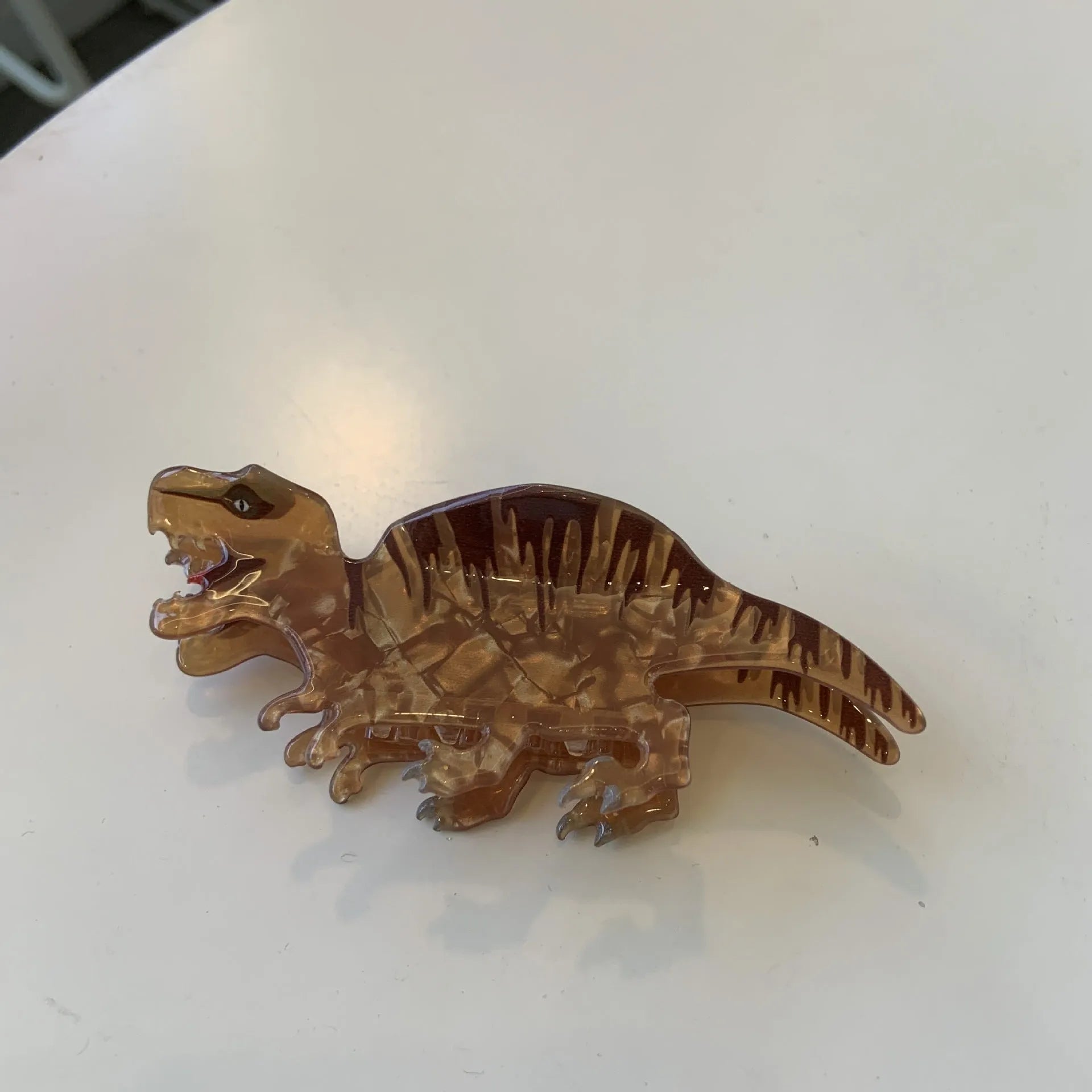 Dinosaur-themed acrylic jaw hair clip showing detailed dinosaur design and secure grip mechanism