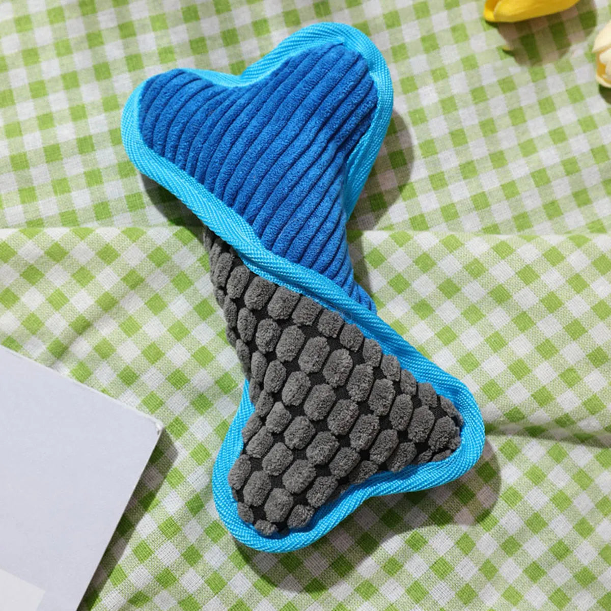 Blue teddy dog toy shaped like a bone with a corn fleece lining and integrated sound module