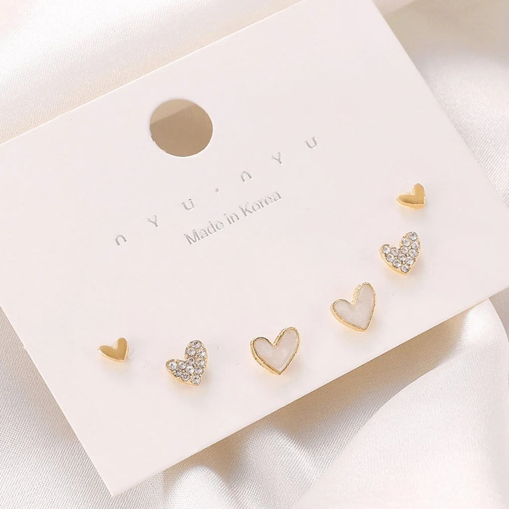 Three pairs of heart-shaped alloy earrings with electroplated finish in gold, black, and pink colours