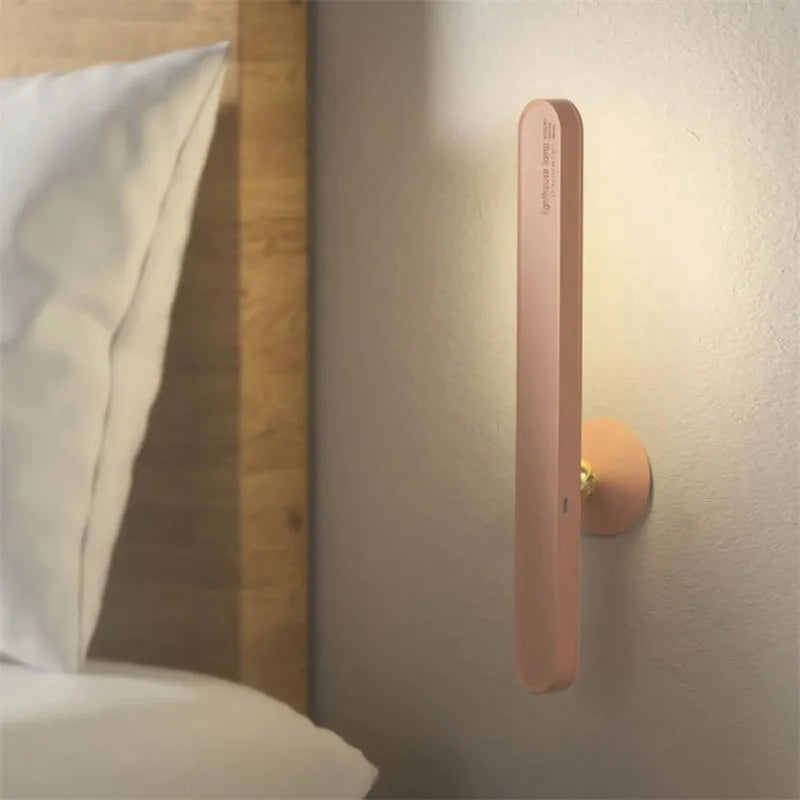 White geometric desk lamp with touch control and magnetic base on a wooden table.