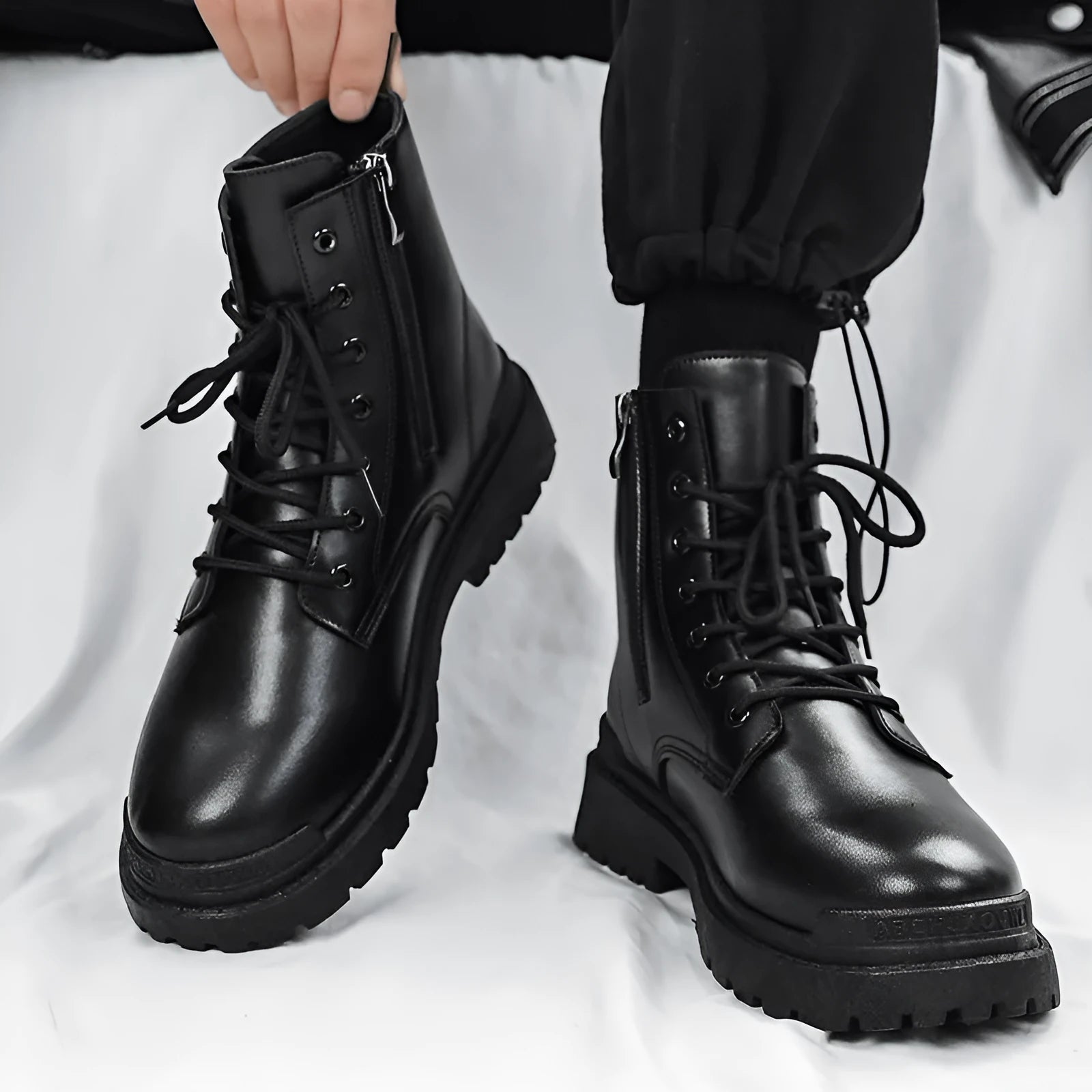 Men's black mid-top waterproof leather boots with rubber soles on size label