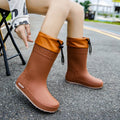 Women's solid colour PVC rain boots in apricot, shown with a non-slip sole.