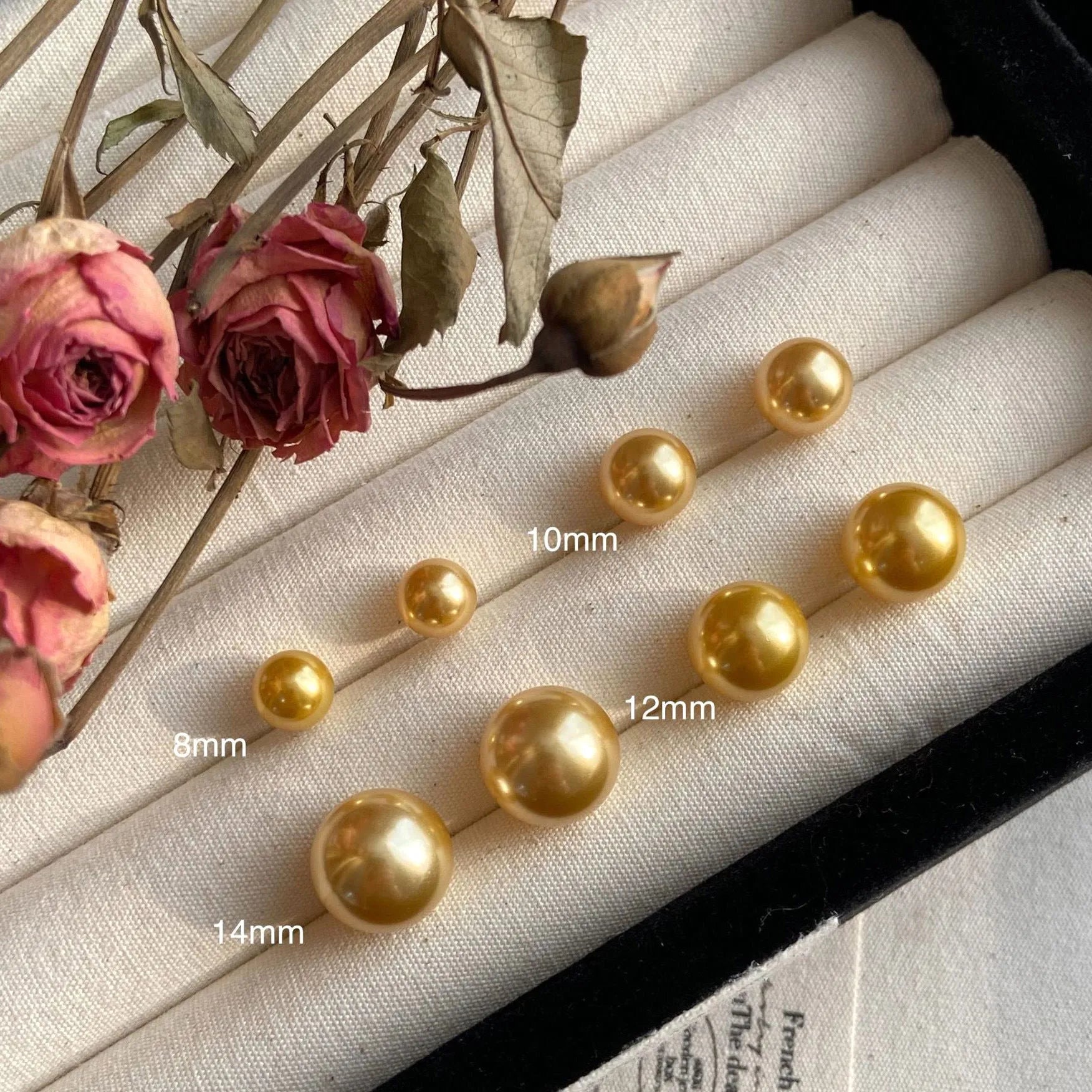 A pair of large pearl stud earrings with a geometric silver setting on a white background.
