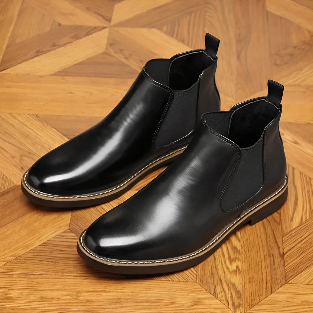 Formal black pointed-toe leather boots with a square heel and rubber sole on a plain background.