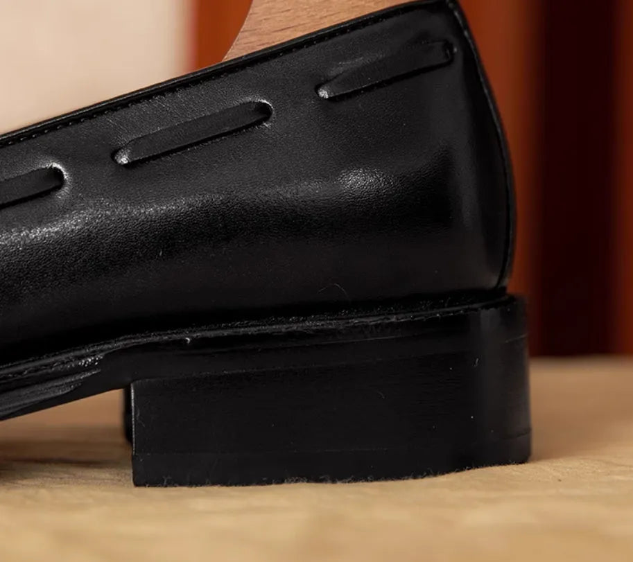 Men's black leather slip-on loafers with fringed detailing and polished finish