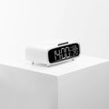 White wireless charger Bluetooth speaker with night light on desk beside smartphone