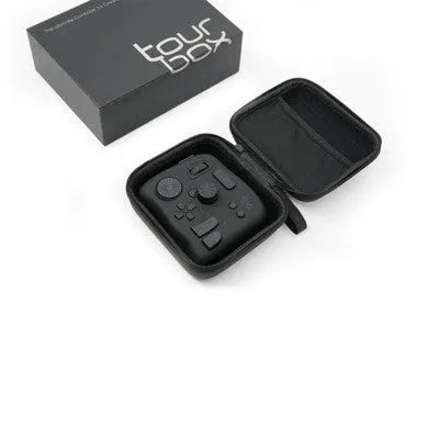 TourBox NEO black USB video editing controller auxiliary keyboard on a desk.