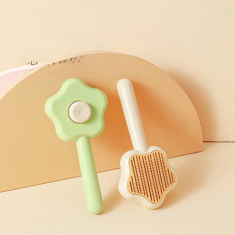 Self-cleaning stainless steel cat comb with green handle, showing 4-row needle design