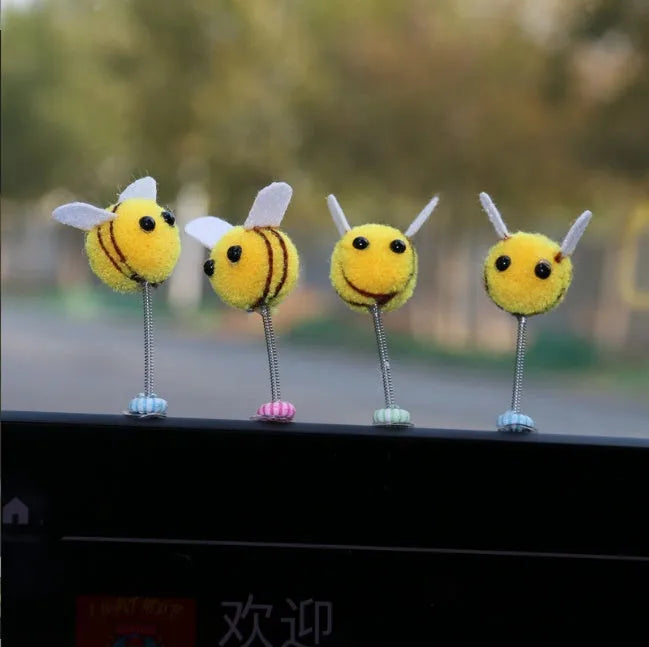 Small yellow and black fur ball bee car ornament with adhesive backing.