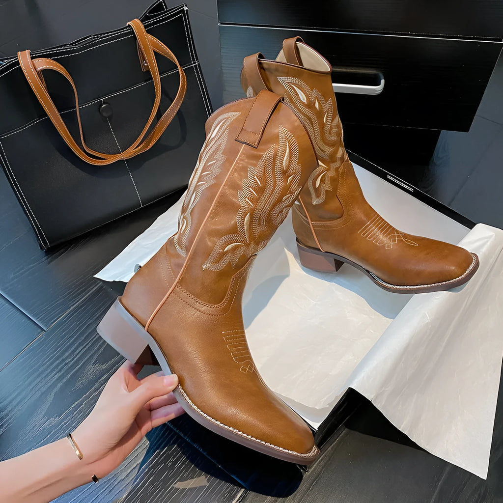 Brown women's mid-calf embroidered Martin boots with a leather lining and low rubber heel.