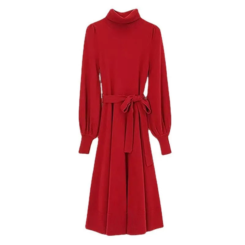 A woman wearing a rose red turtleneck knit dress with long sleeves, an elastic waist, and a loose mid-length hem.