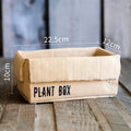 Cement flowerpot with brown paper box texture and bottom drainage holes on a floor.