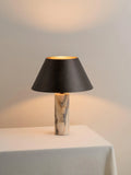 Black modern marble table lamp with minimalist design on wooden surface