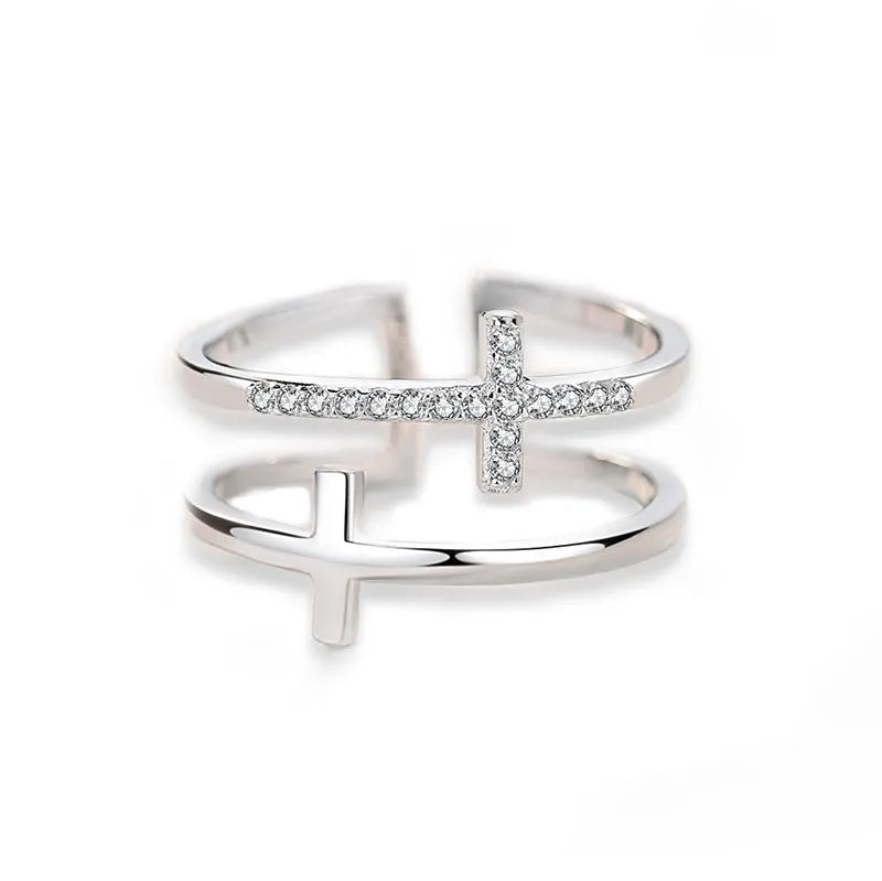 Adjustable open copper ring with geometric double cross design and inlaid zircon stones in gold colour finish.