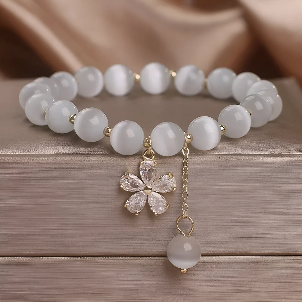 Women's single loop bracelet with white cat's eye stones and decorative tassel featuring morganite safety buckle