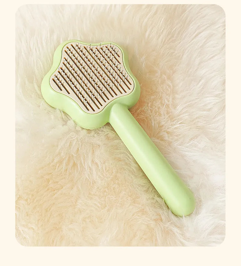 Self-cleaning stainless steel cat comb with green handle, showing 4-row needle design