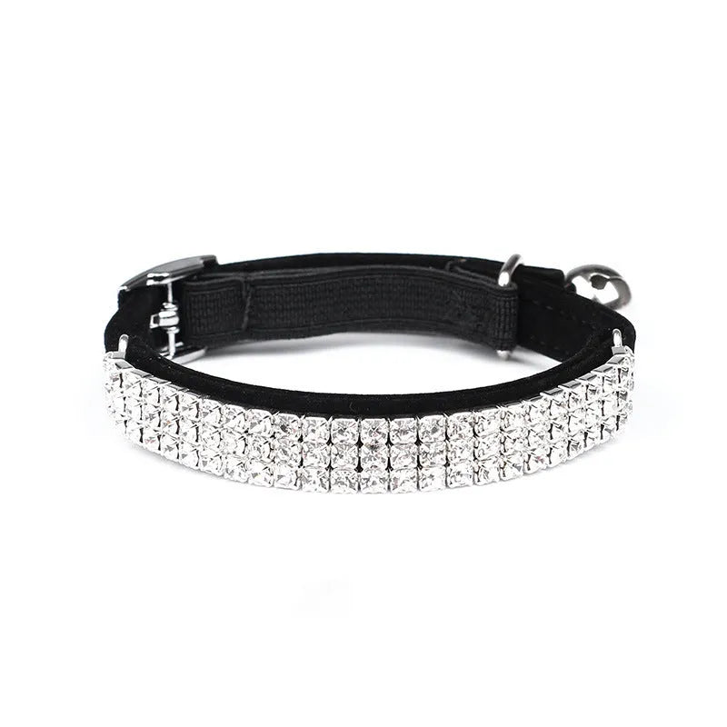 A soft red velvet cat collar with a line of rhinestones, showing the adjustable buckle.