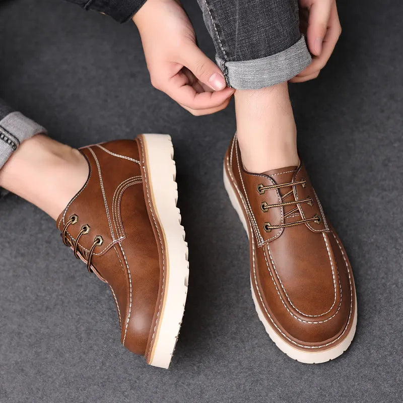 Men's black low-top Martin boots with a round toe and non-slip rubber sole on a plain background.