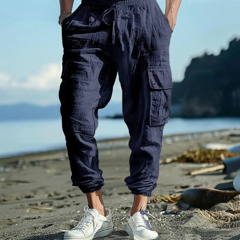 Man wearing khaki linen casual trousers with ankle-tied cuffs and multiple pockets.