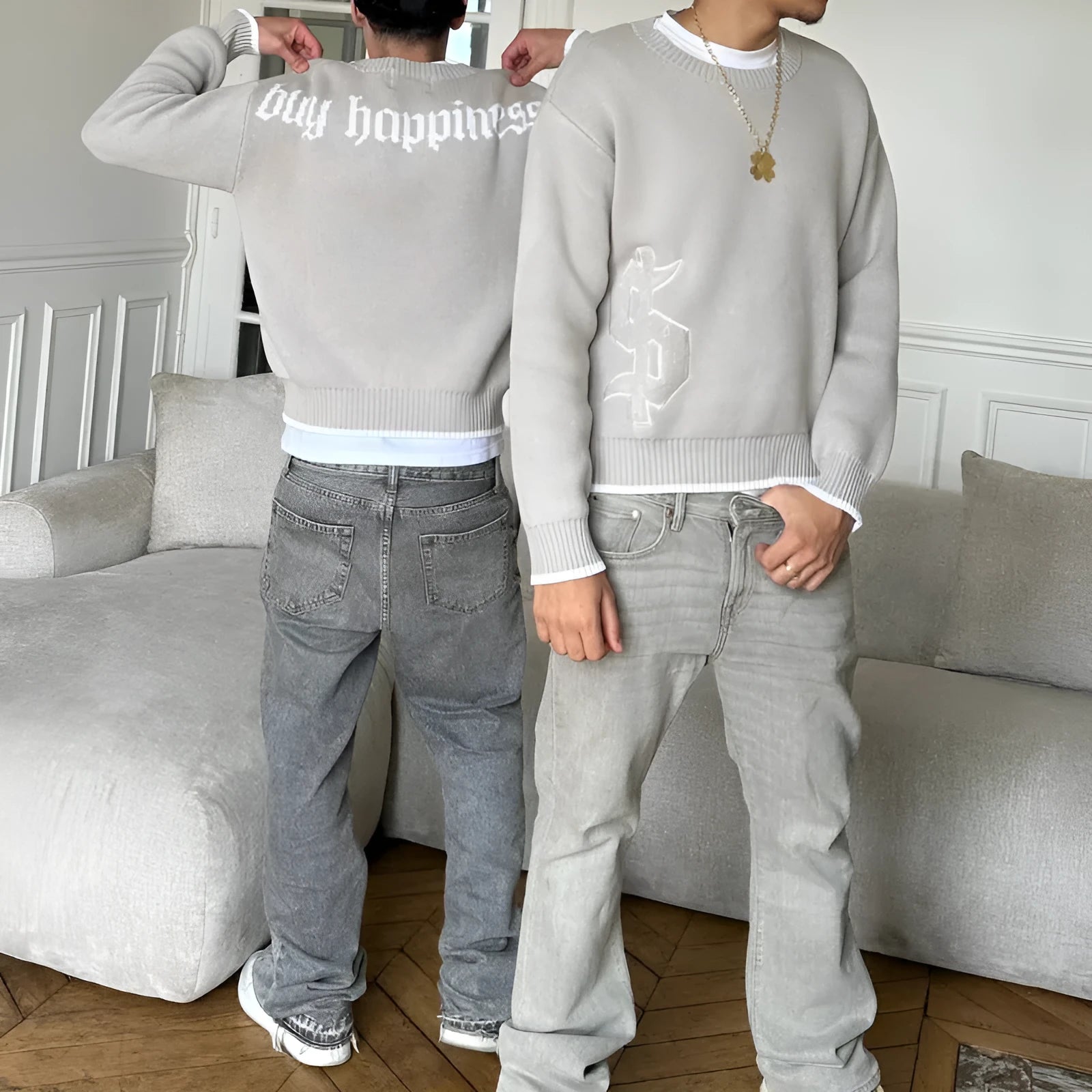Grey loose-fitting jacquard knit coat on a hanger, showing long sleeves and textured knit pattern.