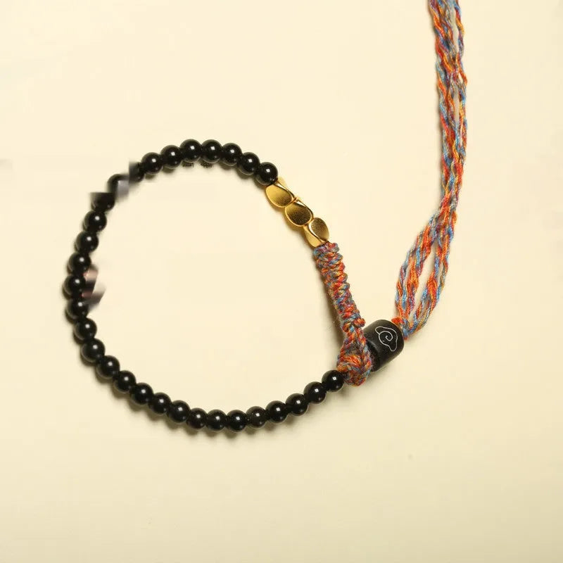 Hand-woven obsidian carrying strap bracelet showing textured weave and 4mm width