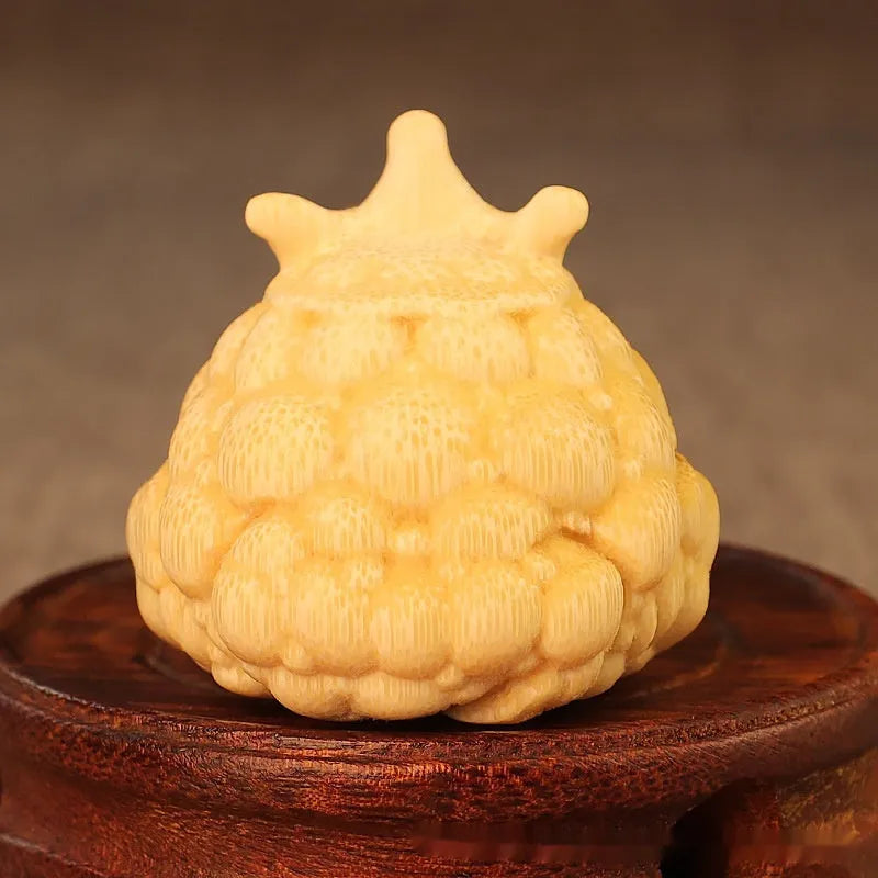 Solid bamboo carving of a cute Crown Princess toad ornament on a wooden surface.