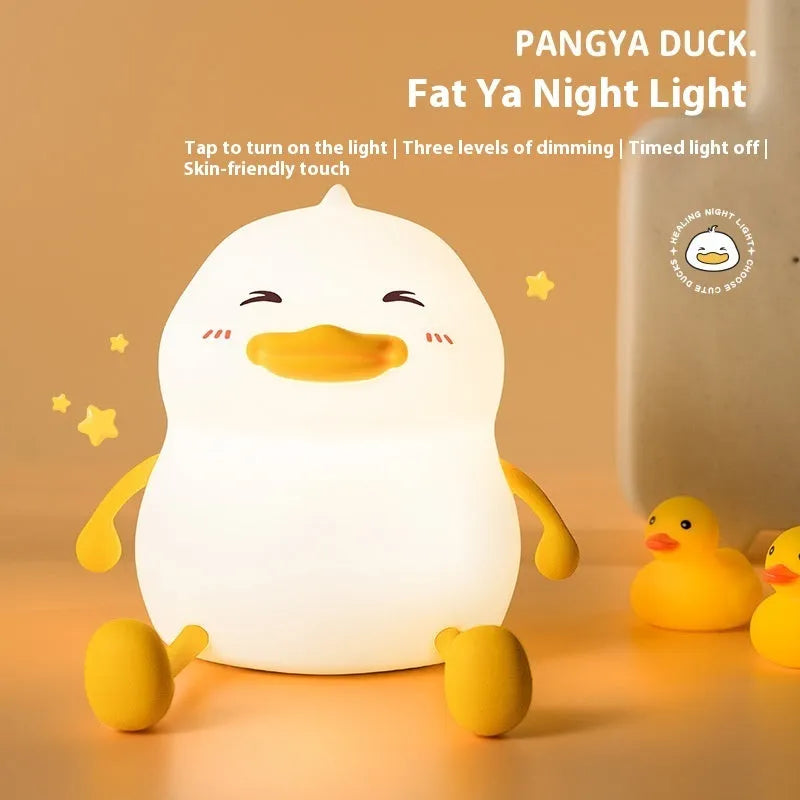 Chubby small night lamp with silicone pat design and integrated phone holder on desk