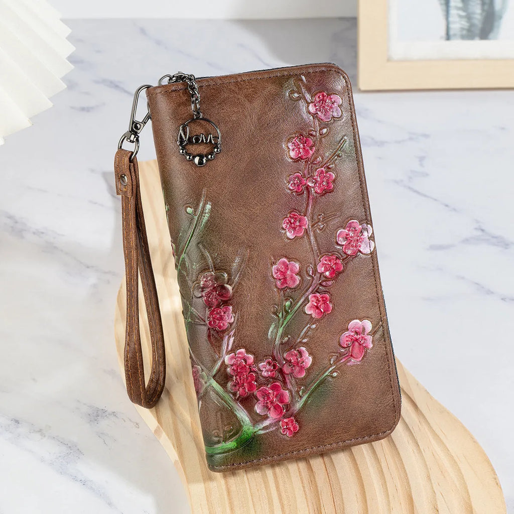 Embossed floral handbag with hand-painted details and a brass zipper in a retro style.