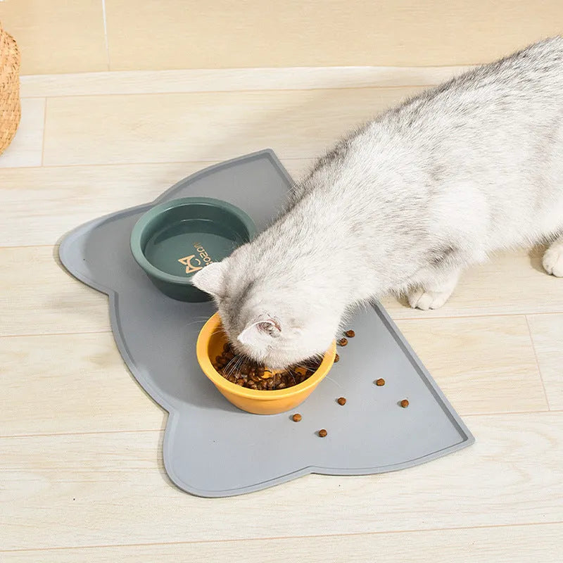 Blue silicone pet feeding mat for dog or cat bowls on a wooden floor.