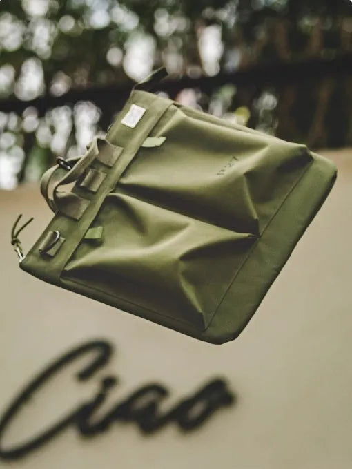 Retro canvas crossbody messenger bag in military green showing laptop compartment and phone storage