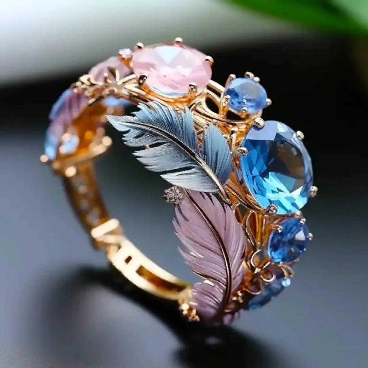 Gold colour brass ring with embossed feather design and small zircon stones on a geometric band.