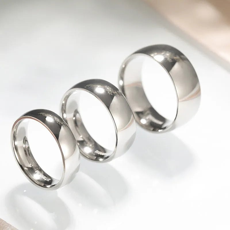 Silver titanium steel band ring shown in different widths on a hand.