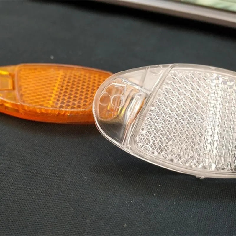 White and yellow plastic bicycle spoke reflectors for wheel safety visibility