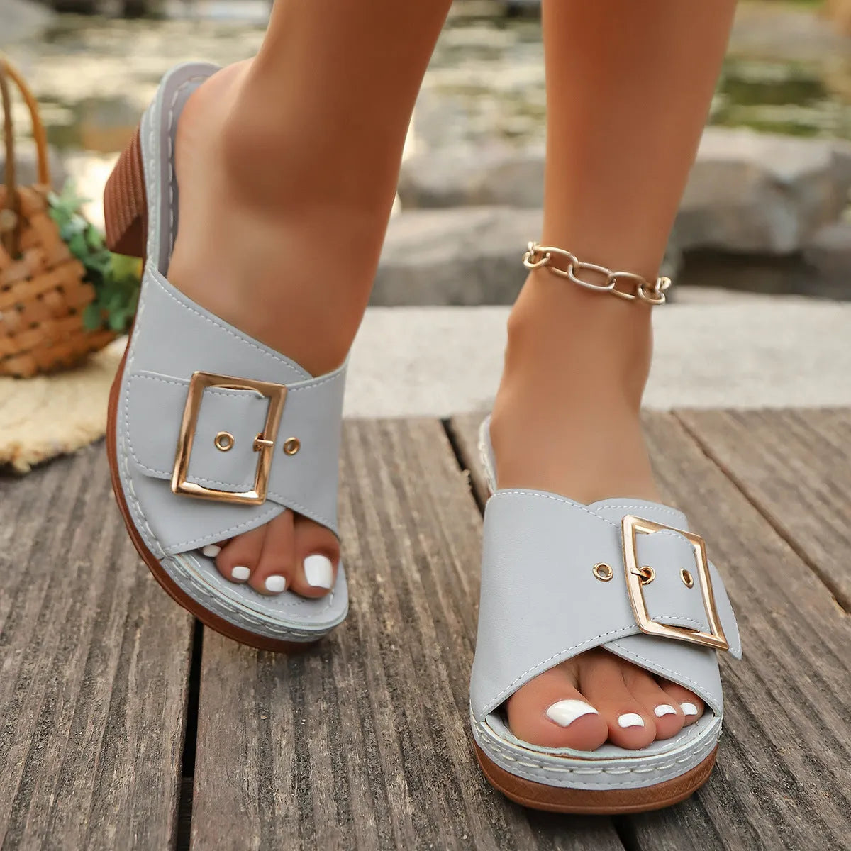 Women's black and light blue chunky heel slippers with a metal buckle closure on a rubber sole.
