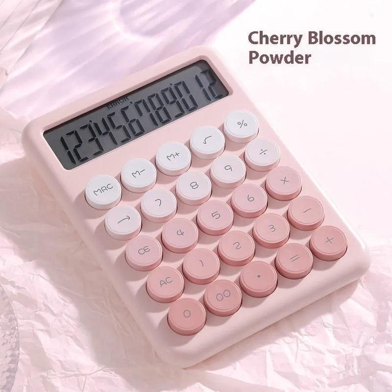Gradient colour desk calculator in violet, cherry blossom pink, glacier blue, and mint green on a white desk.