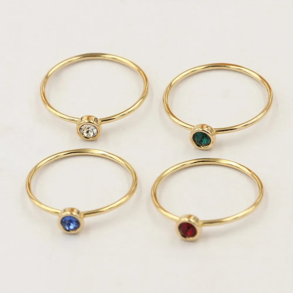 Women's 14K gilded copper knuckle ring with zircon accents in green, shown on a model's finger.