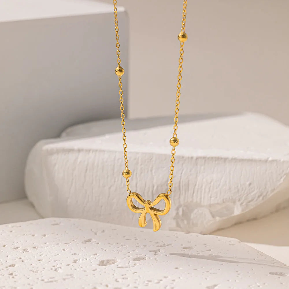 Gold titanium steel bow necklace with cross chain design, adjustable 41-50cm length