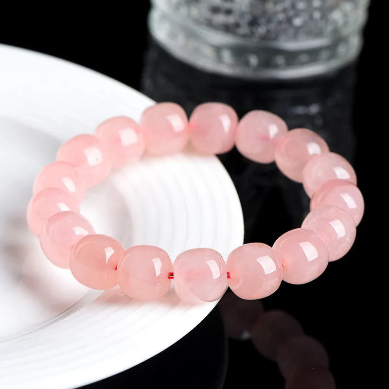 Pink natural crystal barrel bead bracelet with geometric shape on wrist